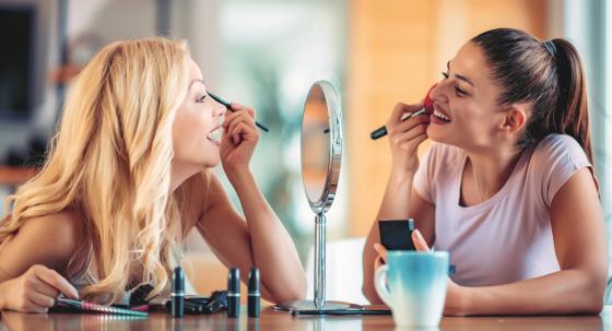 Zwei Frauen tragen Makeup auf